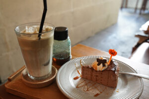 かぼちゃのピックが添えられた生チョコレートバスク。左手奥にはほうじ茶ラテ。