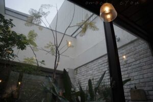 店舗内のパティオ、3面ガラス張りでのびのびとしたグリーンが見える